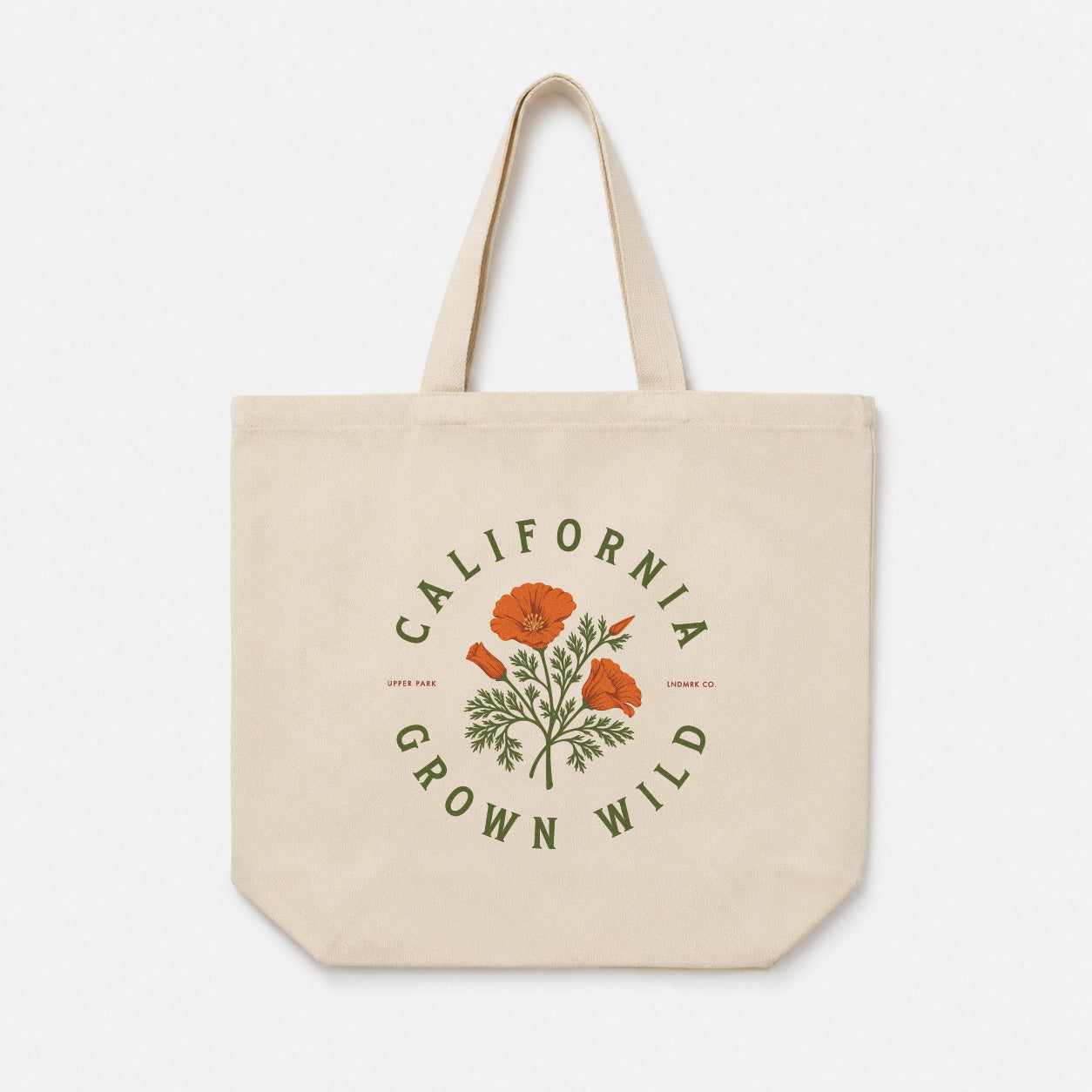 A natural canvas tote bag with a printed graphic featuring orange poppies and green leaves, surrounded by the text 'CALIFORNIA GROWN WILD' in green. The bag is shown against a plain, light gray background.