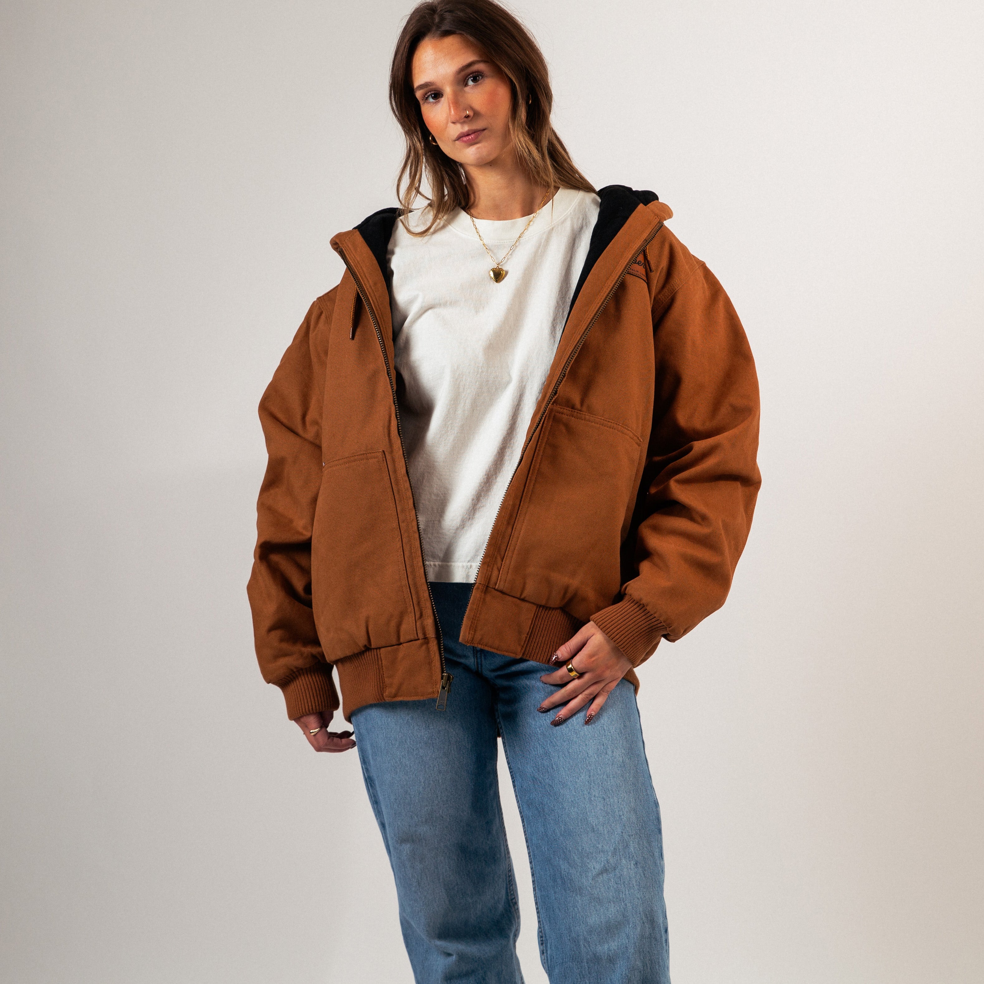 Woman wearing a brown jacket over a white shirt and blue jeans on a plain background - Cultivators Upper Park Duck Canvas Jacket