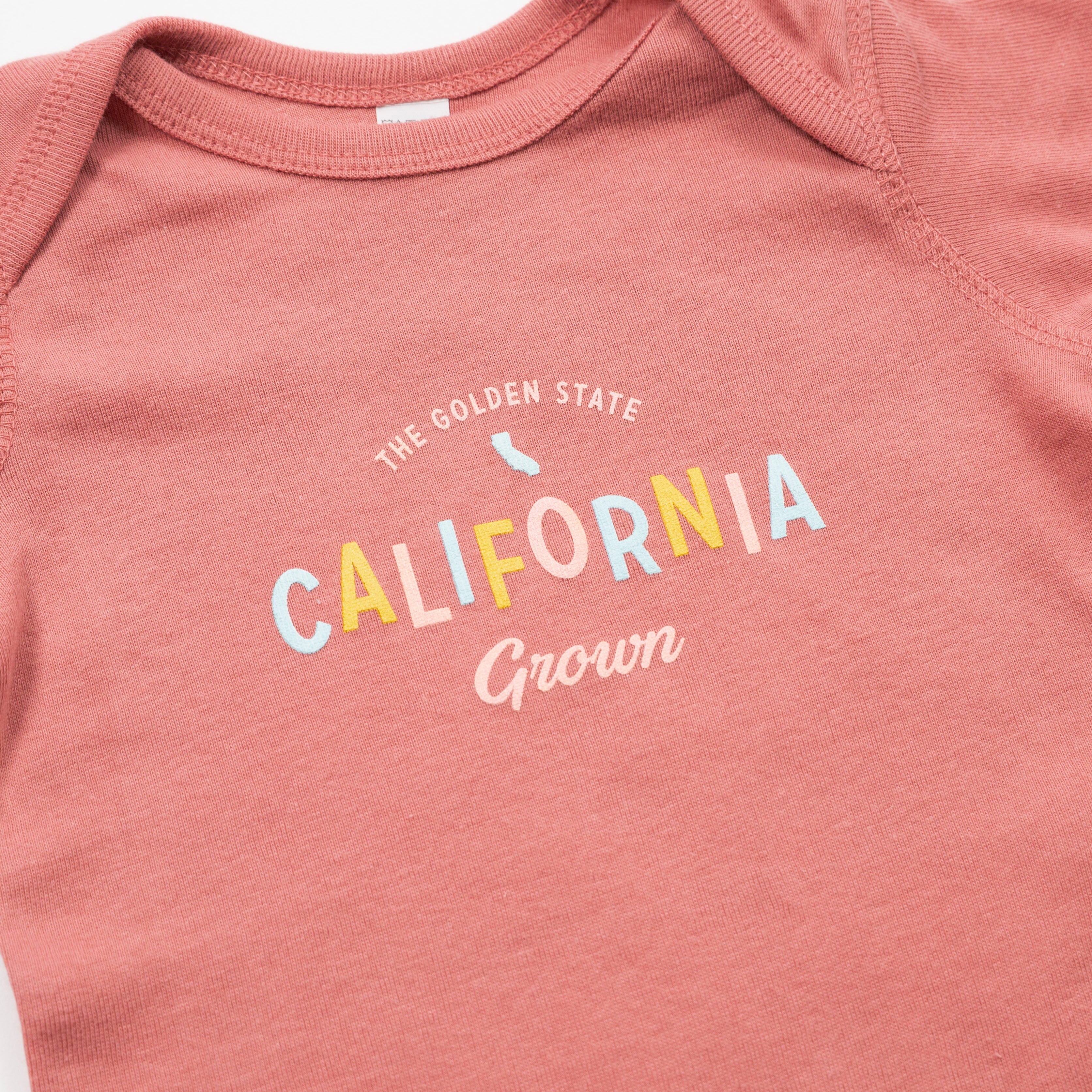 Pink baby onesie with 'California Grown' text on a plain background - Upper Park Baby Onesie California Collection