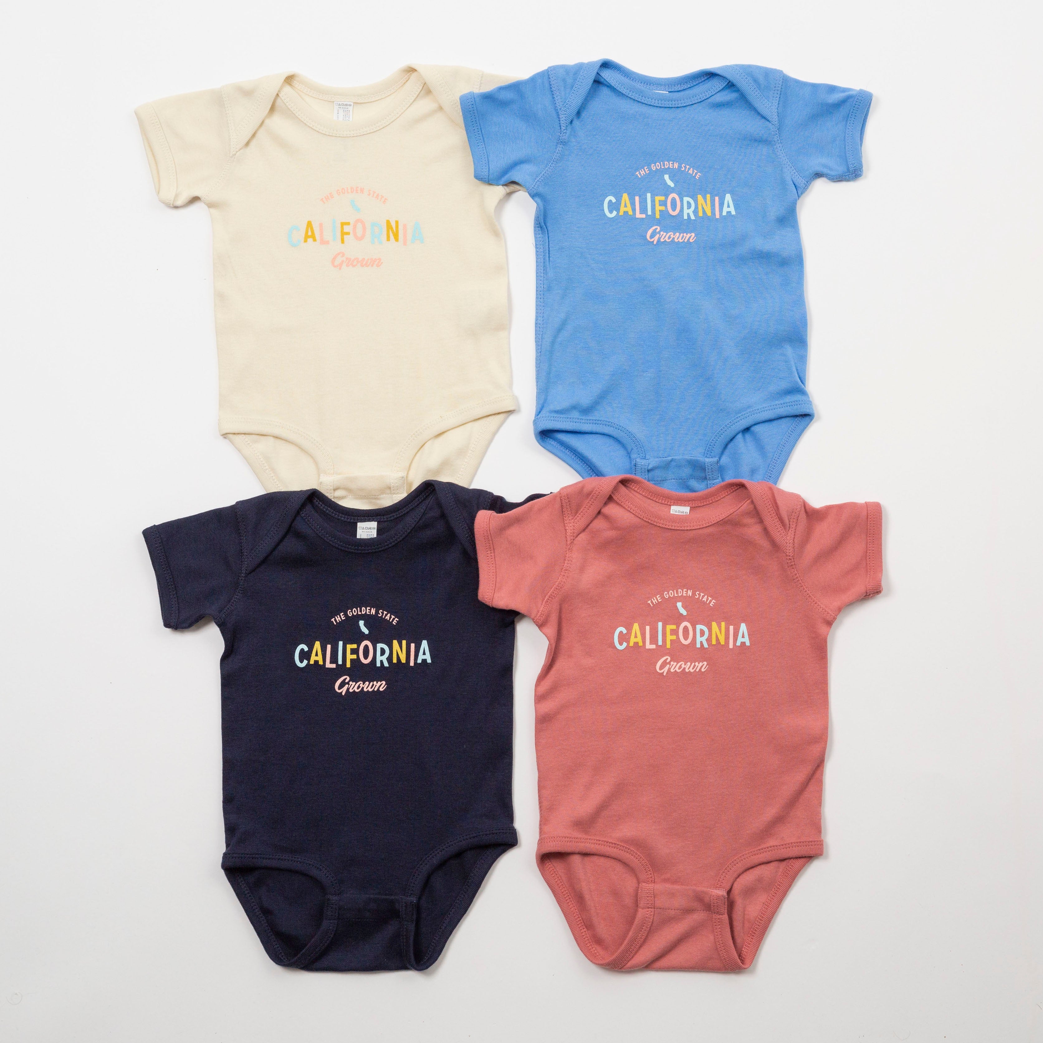 Four baby bodysuits in different colors with 'California Grown' text on a white background - Upper Park Baby Onesie California Collection