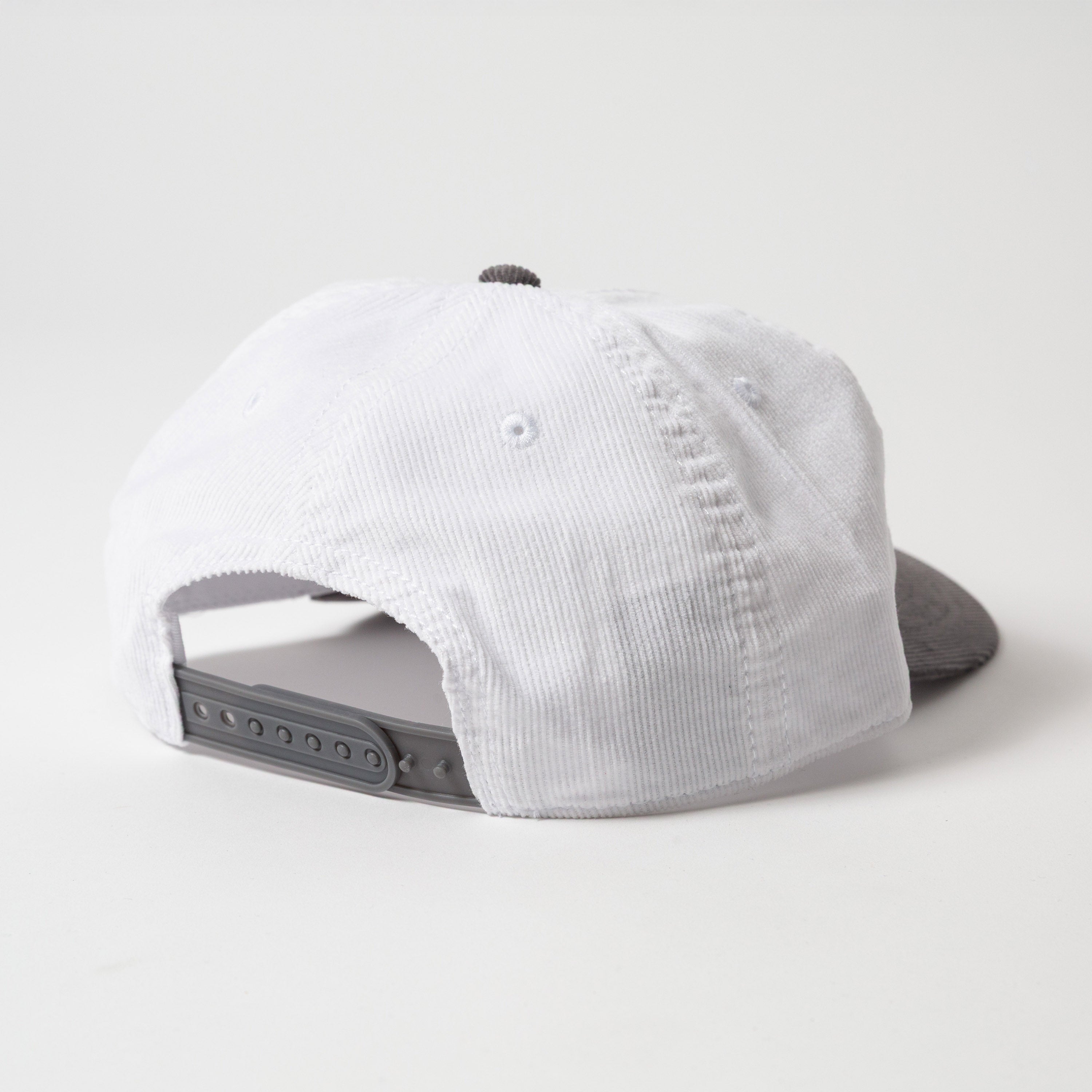 Menlo Embroidered Corduroy Hat - Backside view of a white and gray cap with 'Upper Park' branding on a white background