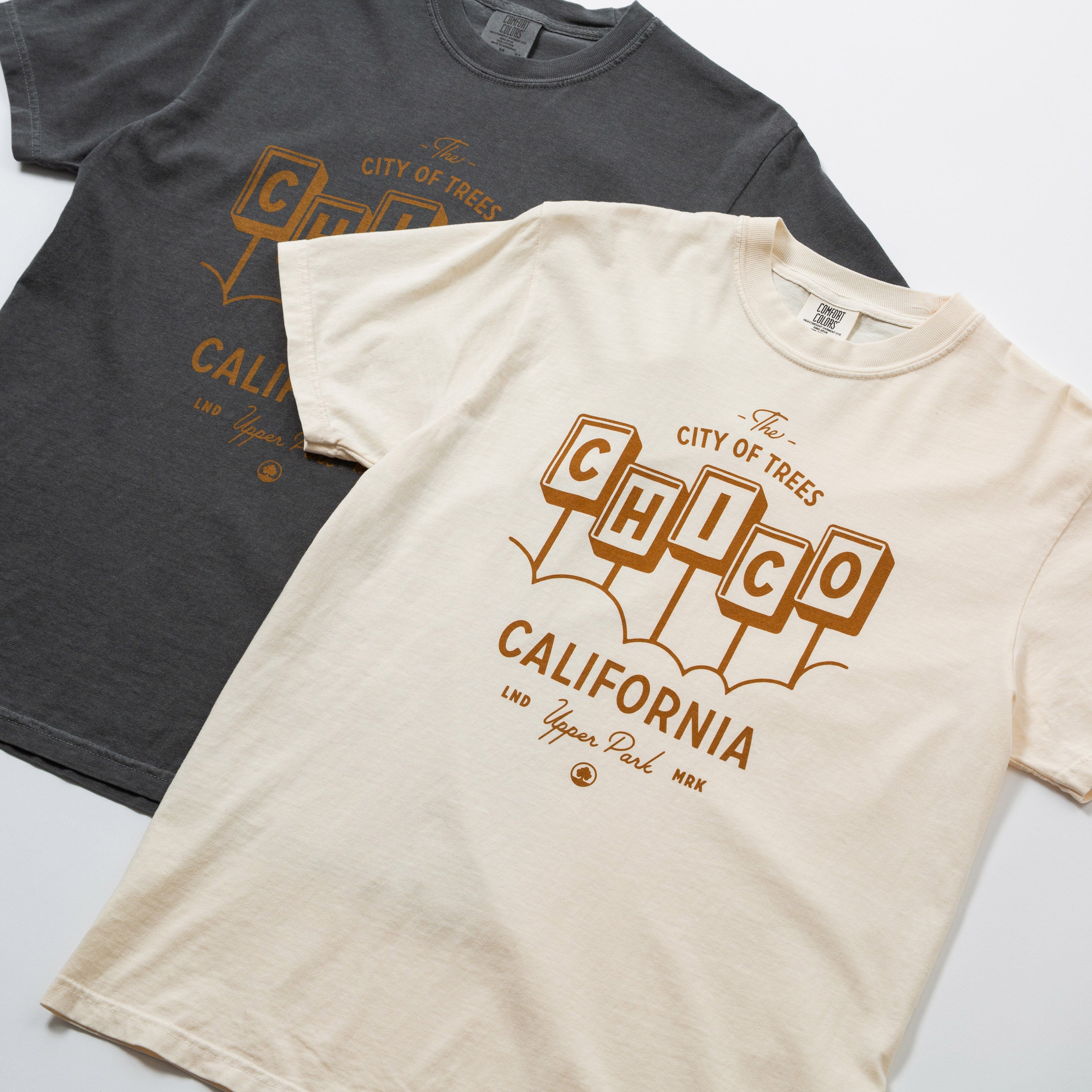 Two t-shirts, one black and one beige, with 'Chico California' text design.