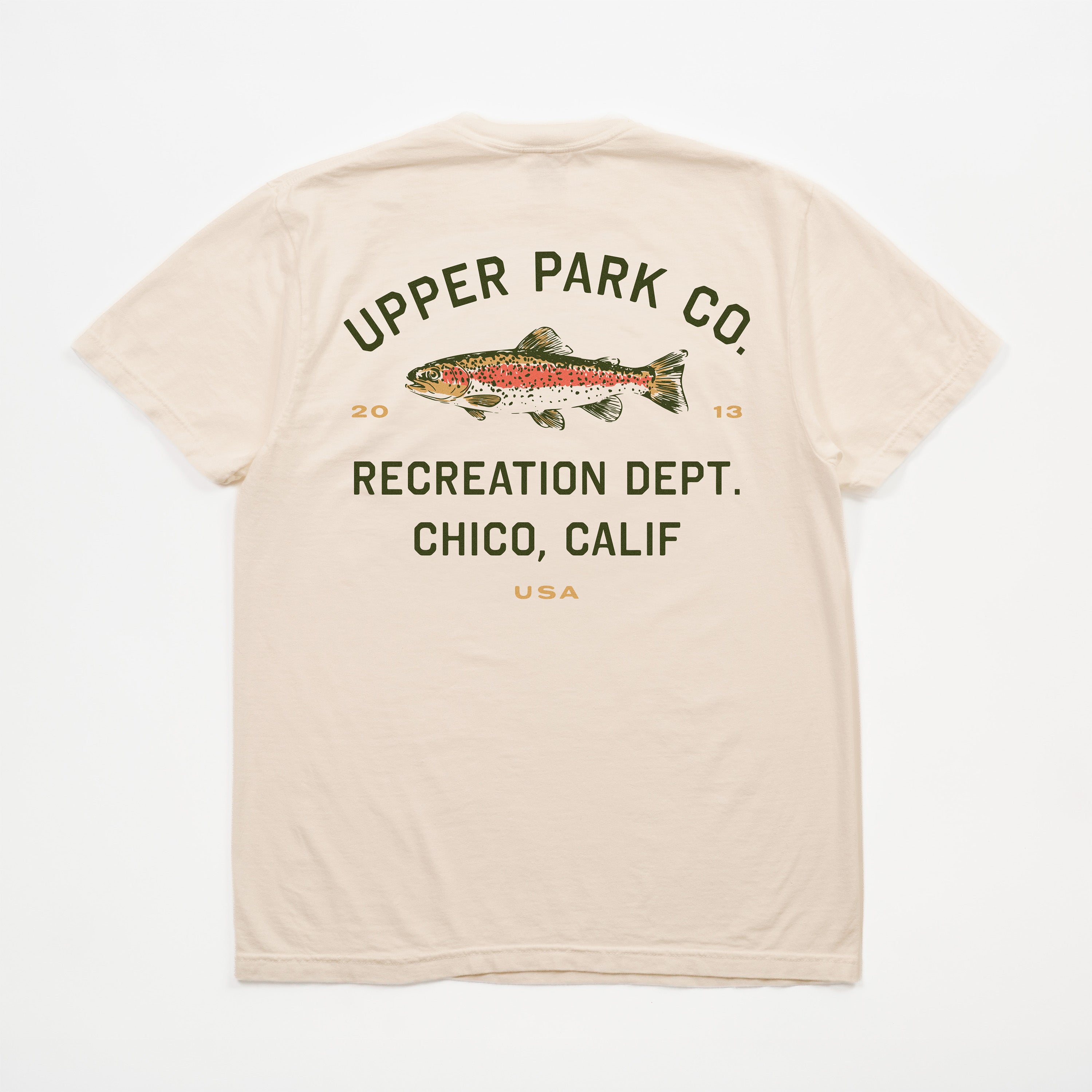 A beige short-sleeve t-shirt shown from the back, featuring a graphic print of a rainbow trout with the text 'UPPER PARK CO. RECREATION DEPT.