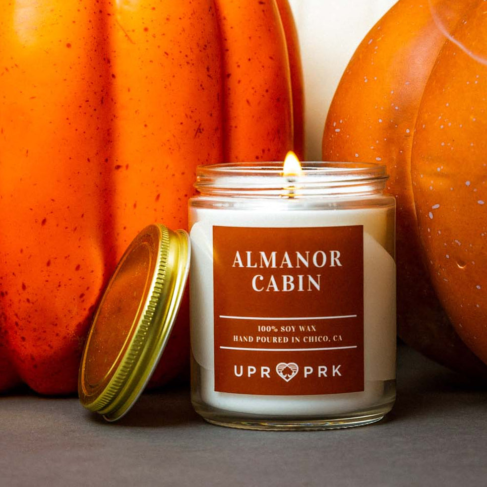 Almanor cabin candle with pumpkins in the background
