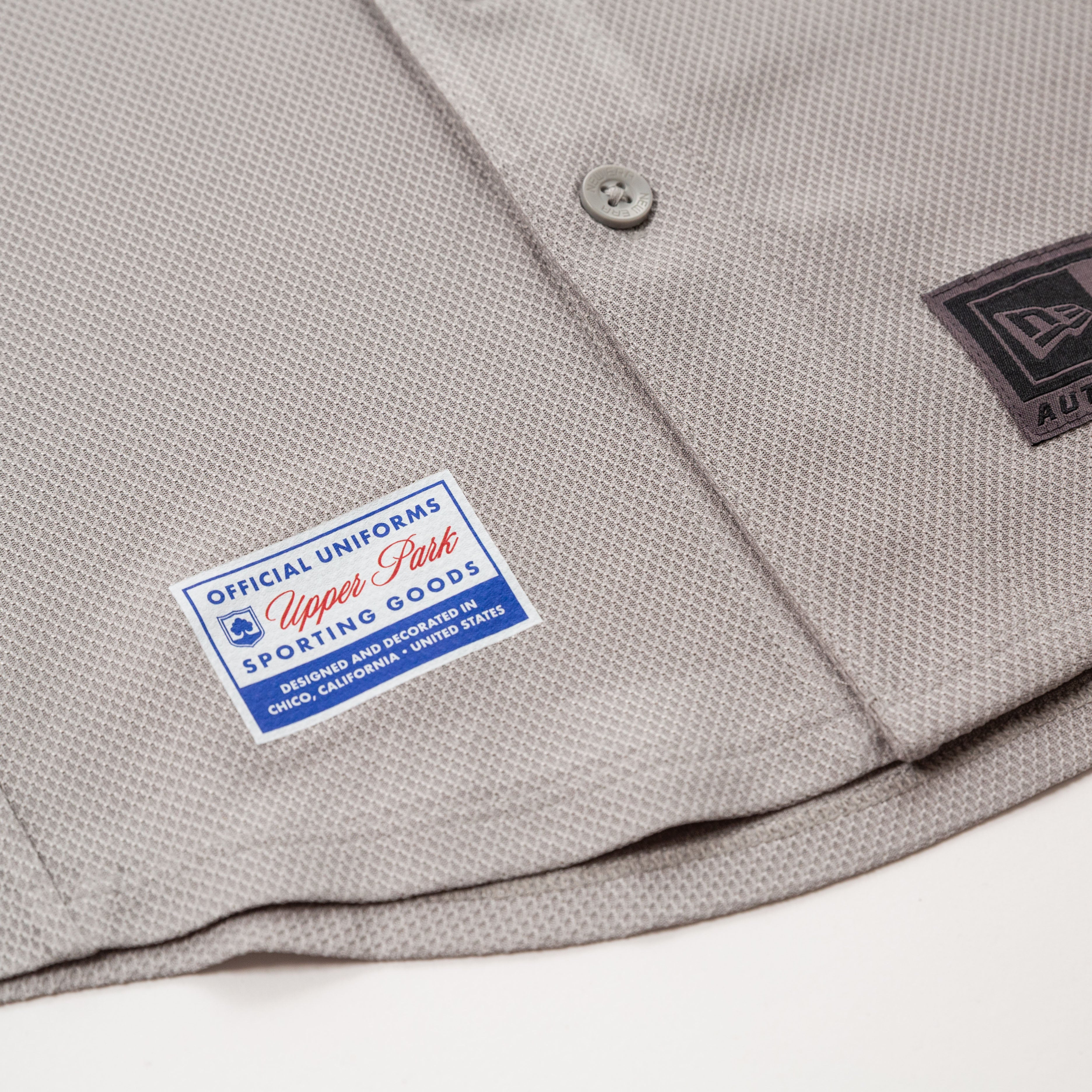 Gray baseball uniform with 'Official Uniforms' label on a white background  - 530 Upper Park New Era Jersey