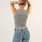 Person wearing a gray tank top and blue jeans on a plain background - Women's Basics - Baby Rib Tank Top