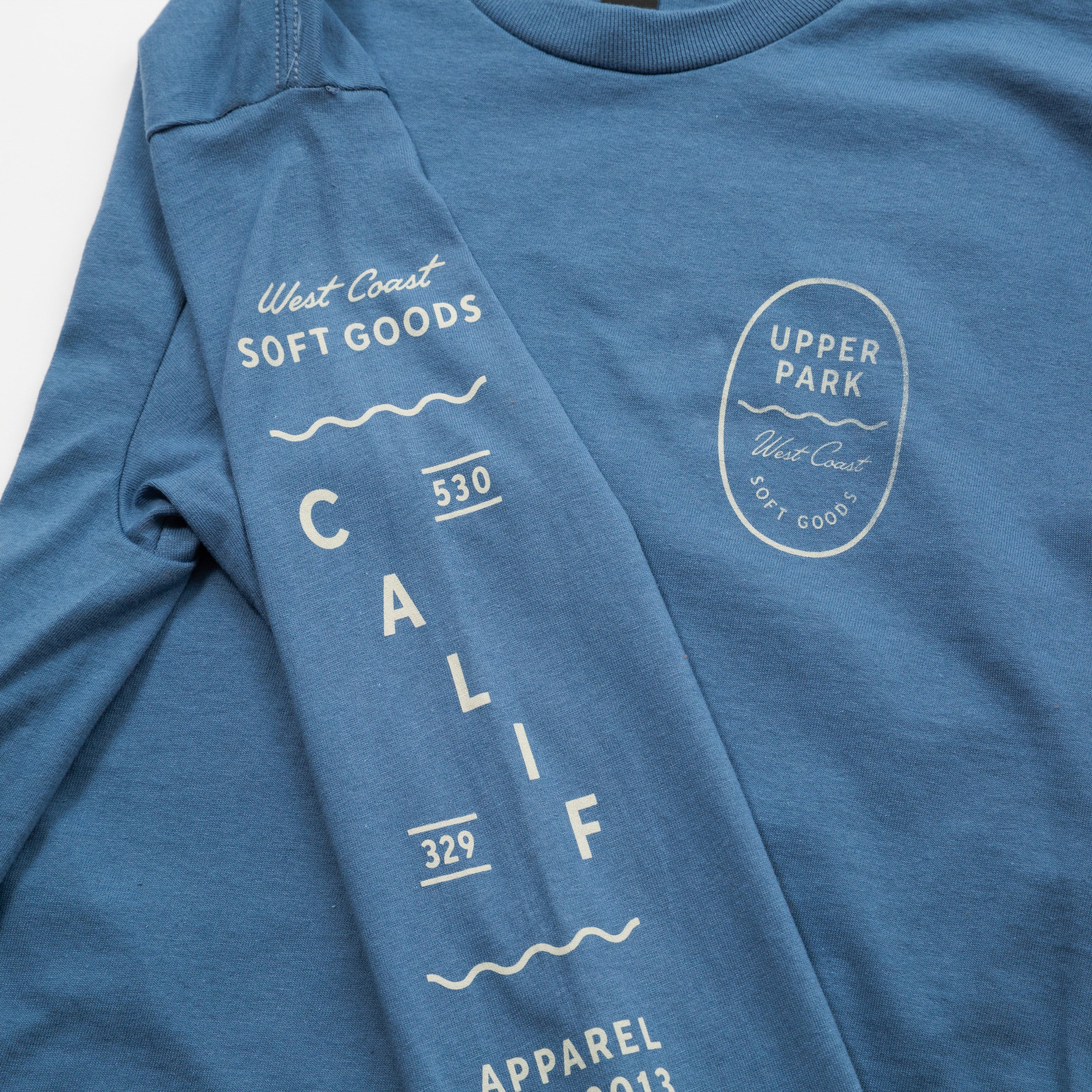 Bay Waves Standard Long Sleeve Shirt - Upper Park Clothing - Blue t-shirt with white text and branding on a white background