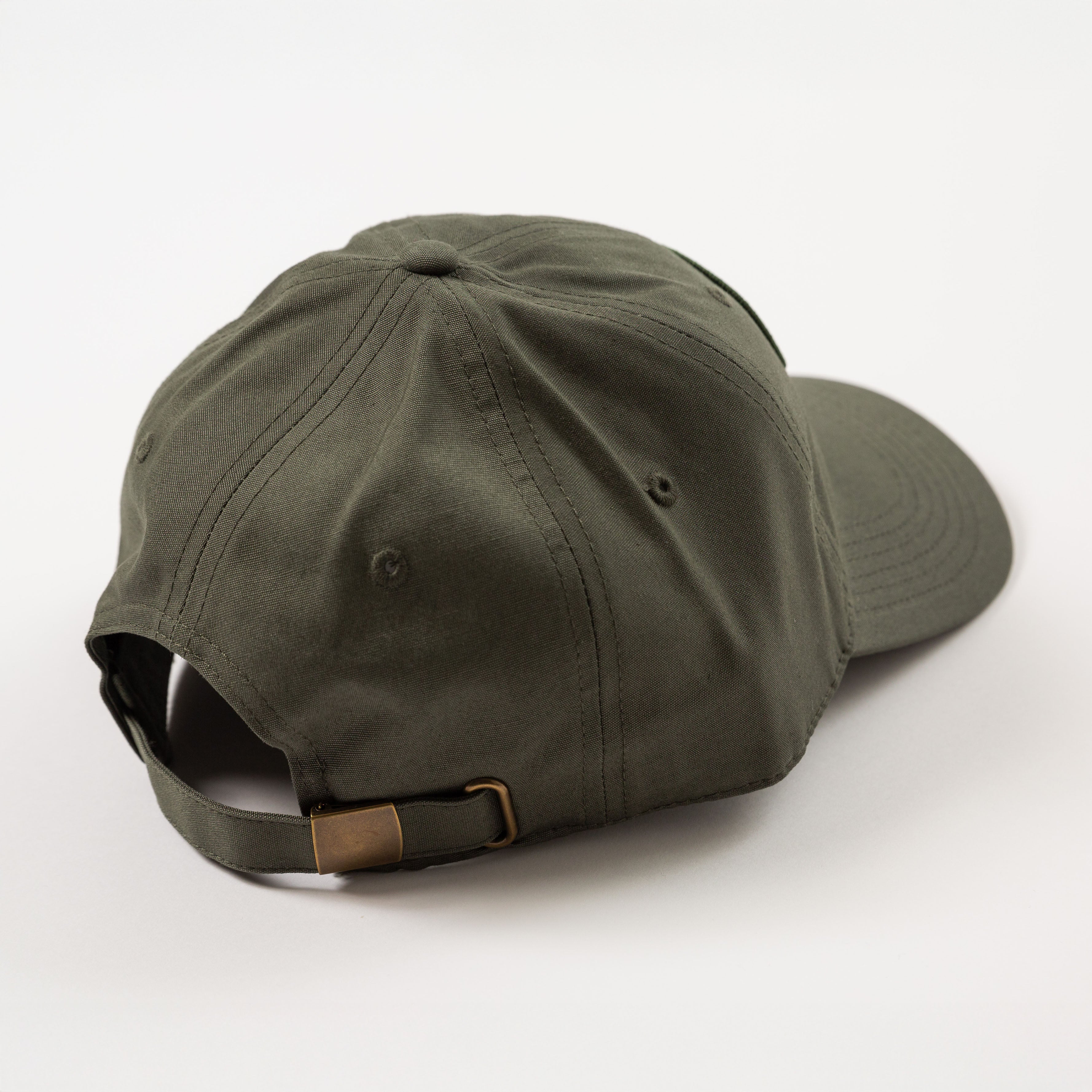 Green baseball cap with a brown strap on a white background