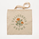 Beige tote bag with 'California Grown' and floral design on a white background