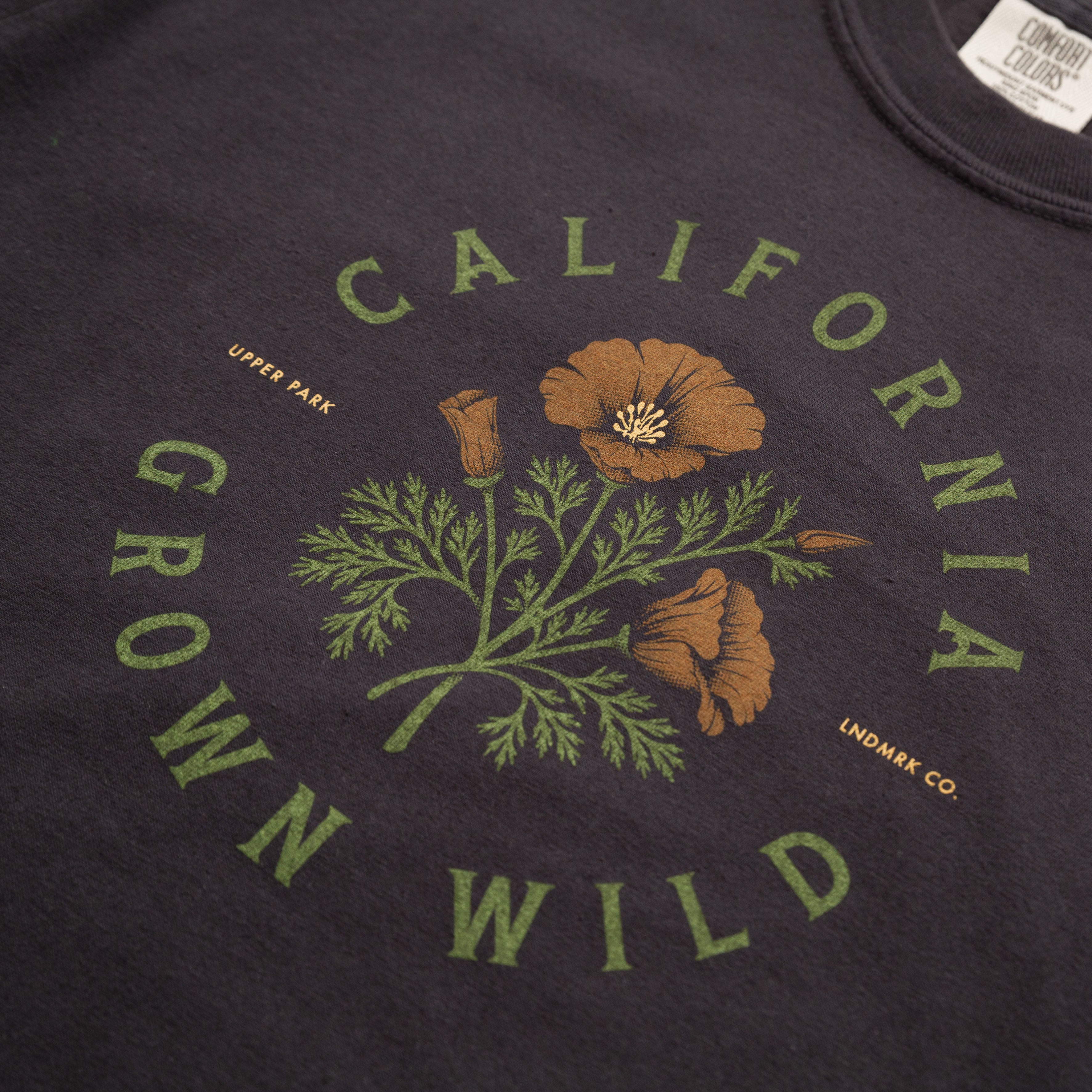 Black t-shirt with 'California Grown Wild' design featuring poppies and green leaves.