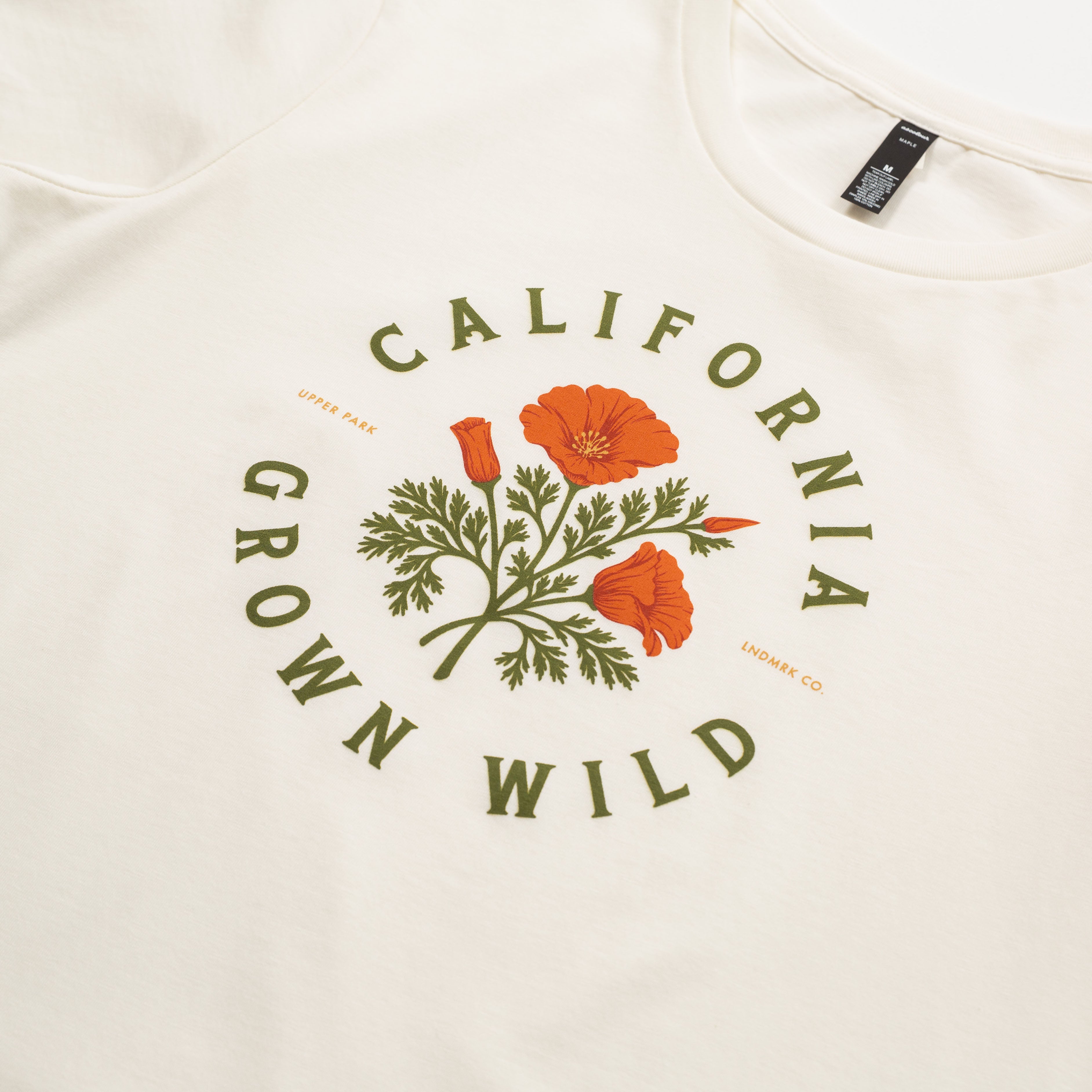 Beige sweatshirt with 'California Grown Wild' design featuring California poppies on a white background.