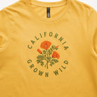 Yellow t-shirt with 'California Grown Wild' graphic featuring poppies on a plain background