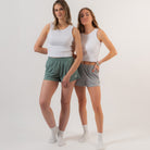 Two women wearing white tank tops and shorts on a plain background - Cotton Gym Shorts