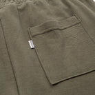 Close-up of a green pocket with a brand label on a matching fabric background