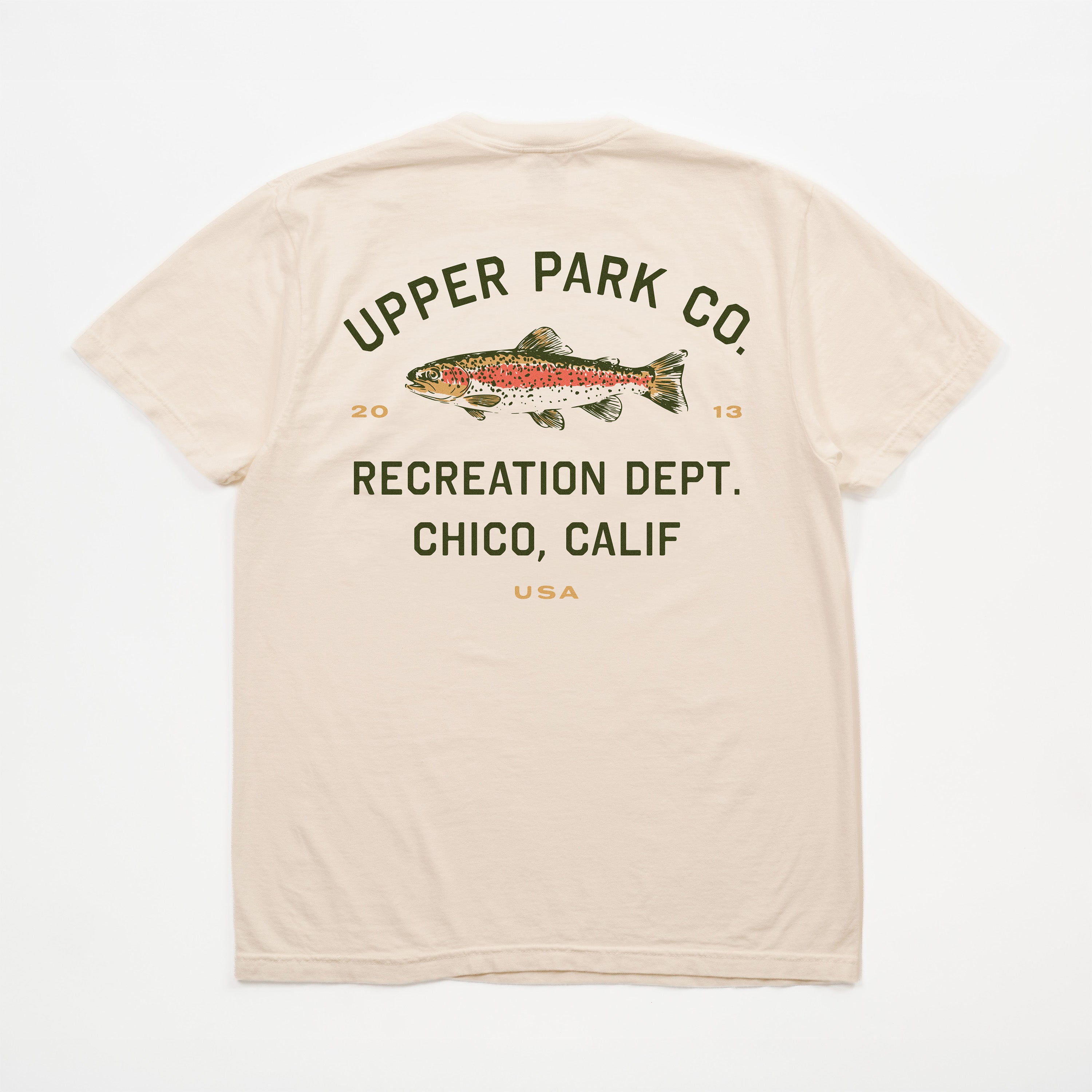 A beige short-sleeve t-shirt shown from the back, featuring a graphic print of a rainbow trout with the text 'UPPER PARK CO. RECREATION DEPT.