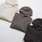 Relax oversize hoodie garment dyed - Three folded hoodies in beige, gray, and black on a light gray background