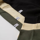 Close-up of a black, yellow, and green sweaters with Upper Park labels on a white background - Upper Park Athletics Sweater Set