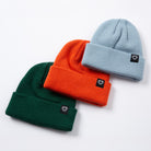 Three beanies in green, orange, and light blue with a brand logo on a white background