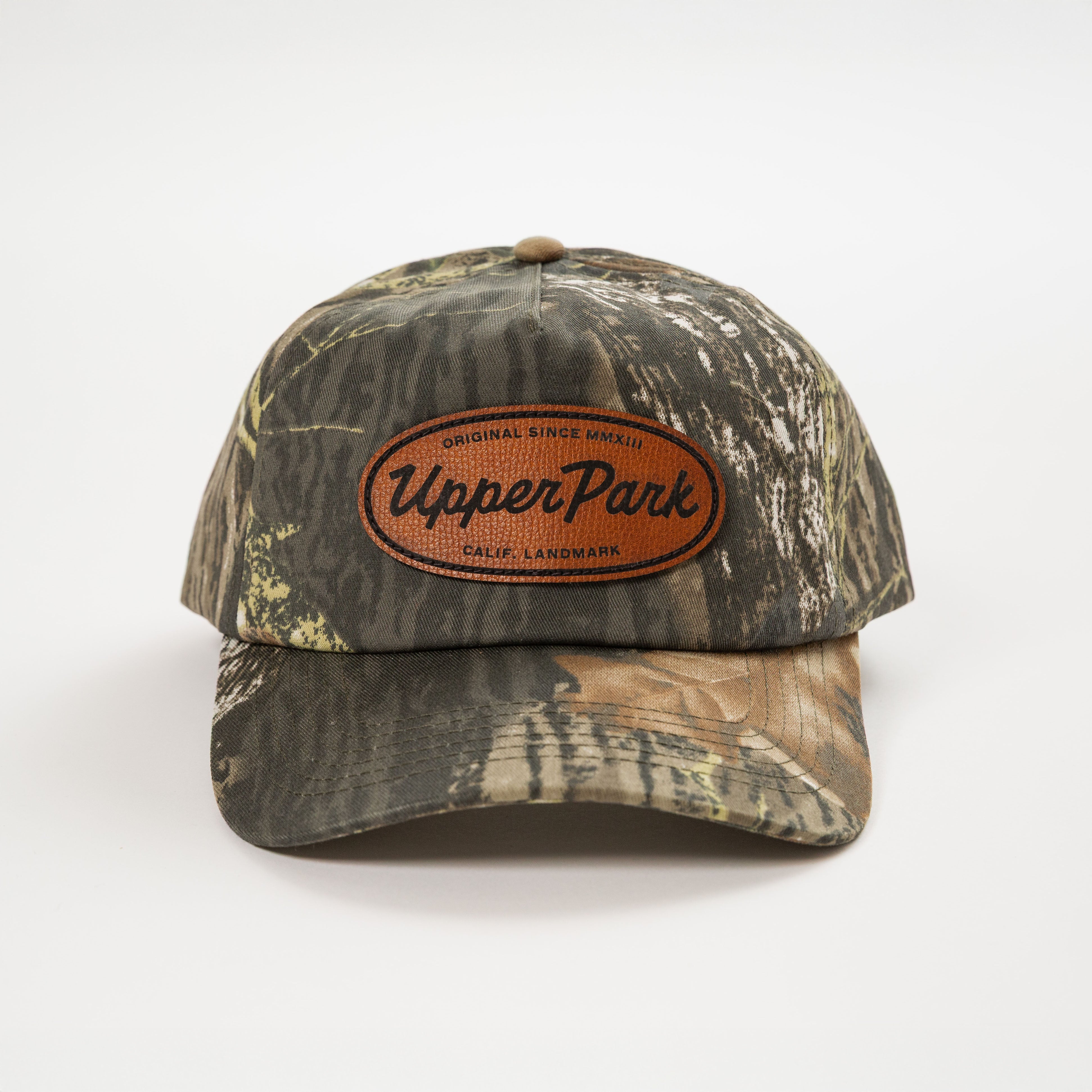 Camouflage baseball cap with leather patch on a white background